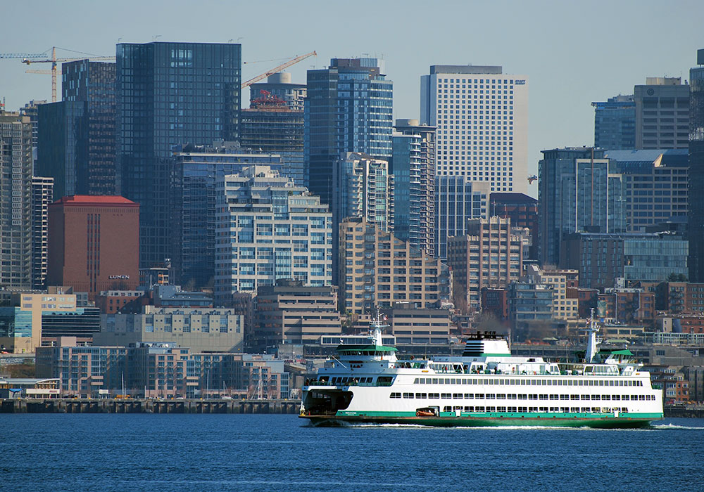 washington state ferry in front of the seattle skyline